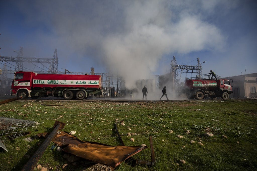 نیروهای امداد در حال خاموش کردن آتش ناشی از حمله ترکیه به یک نیروگاه برق در قامشلو. عکس: AFP
