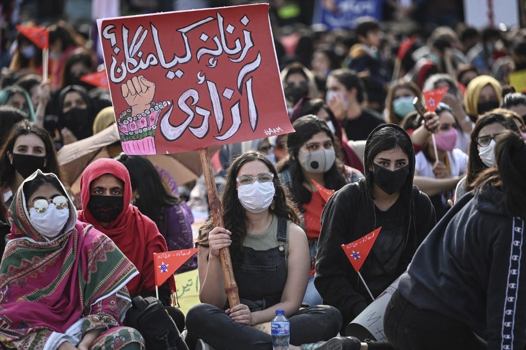عکس مربوط به تظاهرات ۸ مارس ۲۰۲۱ زنان در اسلام‌آباد - جمعی از زنان روی زمین نشسته‌اند. (عکس از Aamir QURESHI / AFP)