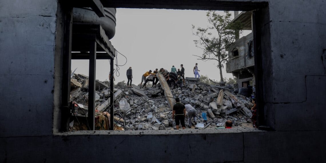فلسطینی‌ها در حال جستجو در ویرانه‌های یک خانه پس از حمله هوایی ارتش اسرائیل