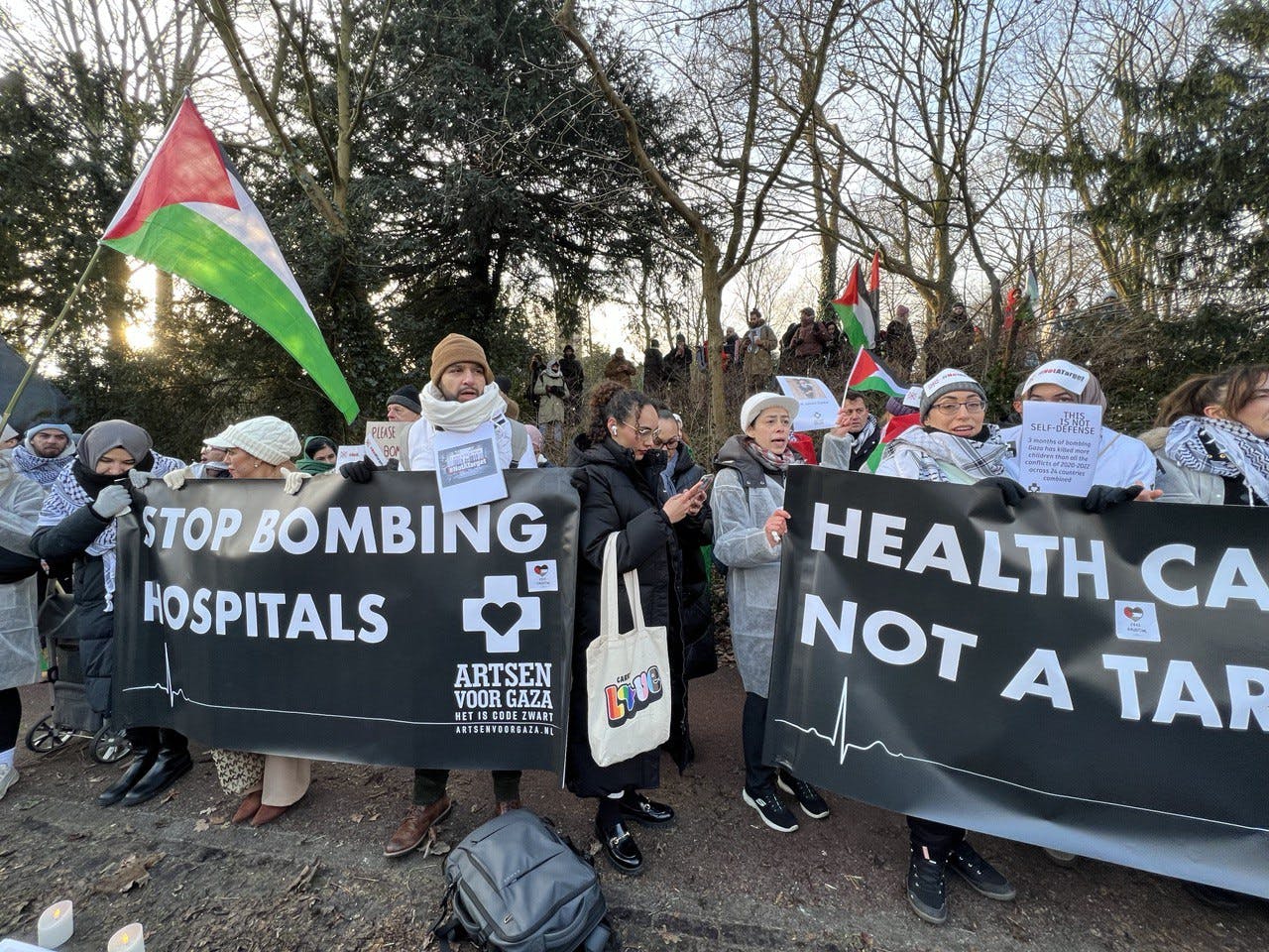 جمعی از هواداران فلسطین با نری که بر روی آن نوشته شده : «بمباران بیمارستان‌ها را متوقف کنید!»