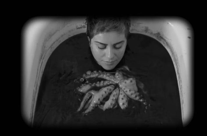 مانیا اکبری در صحنه‌ای از فیلم «چطور جرأت کردی این آرزوی مزخرف را بکنی؟» در وان حمام دراز کشیده در حالی که روی بدنش را اختاپوسی زنده گرفته است و همراه اوست. آب وان حمام به رنگ سیاه است.