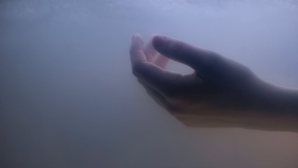 دست یک زن در میان دود یا هاله ابری