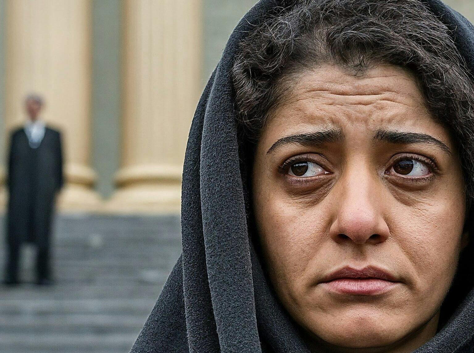تصویر یک زن ایرانی مقابل ساختمان دادگاه. مردی در پس‌زمینه دیده می‌شود.