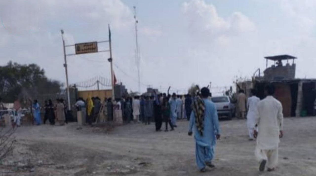 عکس نمای دور پاسگاه انتظامی ریمدان در بلوچستان ایران را نشان میدهد که گروهی از مردم با لباسهای بلوچی مقابل آن تجمع کرده‌اند