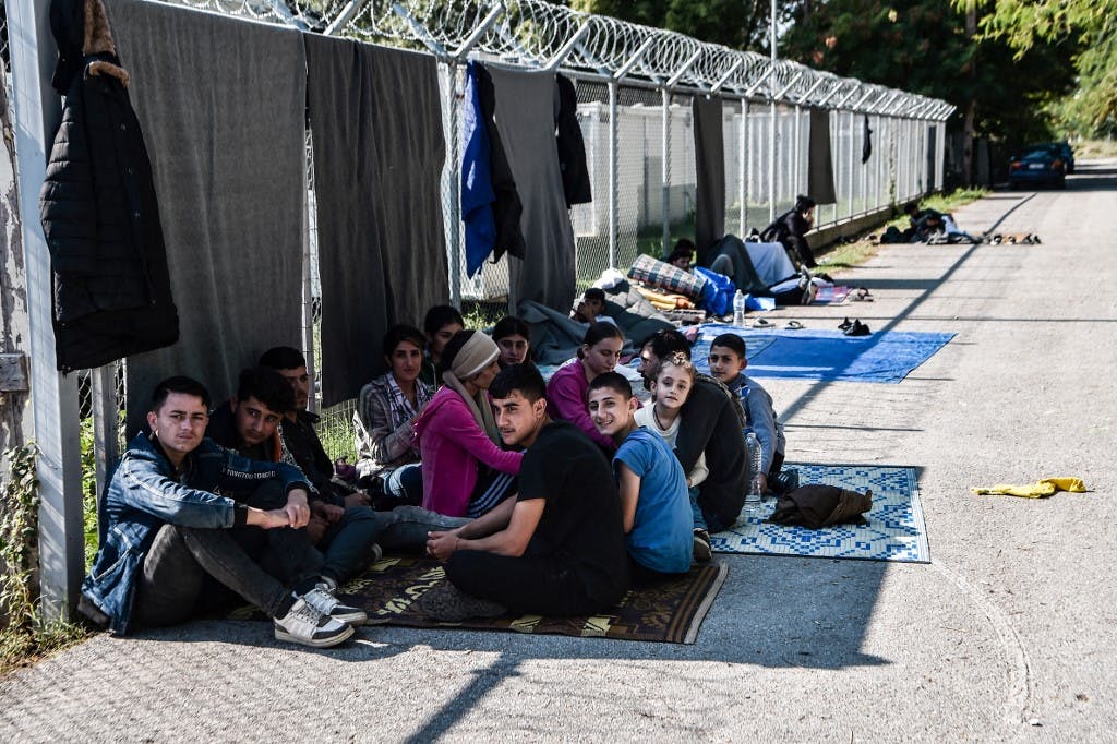 تصویری از یک کمپ پناهجویی در شهر سرس یونان. کودکان بر روی زمین نشسته‌اند.