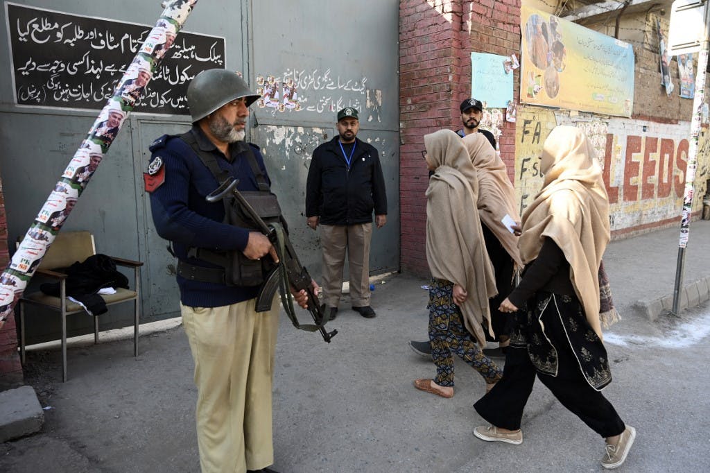 ورود زنان برای رأی دادن در انتخابات سراسری پاکستان در پیشاور در ۸ فوریه ۲۰۲۴، پلیس در خارج از یک مرکز رأی گیری نگهبانی می‌دهد.