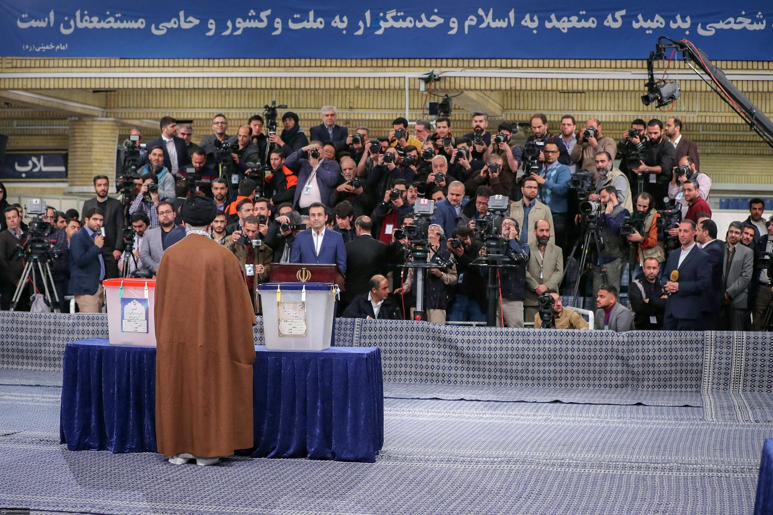 جمعیت خبرنگاران و عکاسان رو بروی علی خامنه‌ای ایستاده‌اند تا او رای بدهد