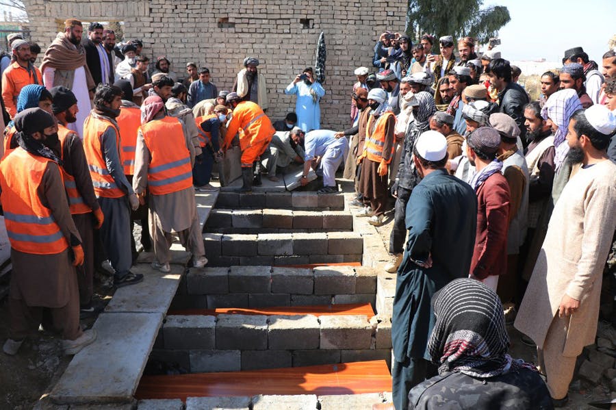 جمعی از مردم خوست افغانستان در گورستان شهدا جمع شده‌اند و جسدهای کشف‌شده در گور دسته‌جمعی را در این گورستان دفن می‌کنند. کارگران شهرداری با لباس‌های نارنجی مشخص‌اند.