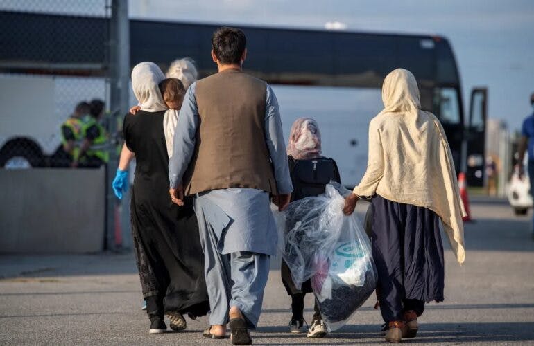 یک خانواده افغانستانی در حال رفتن به سمت اتوبوسی که آنها را به اردوگاه‌های مرزی می‌برد تا ایران را به اجبار ترک کنند. عکس: آرشیو