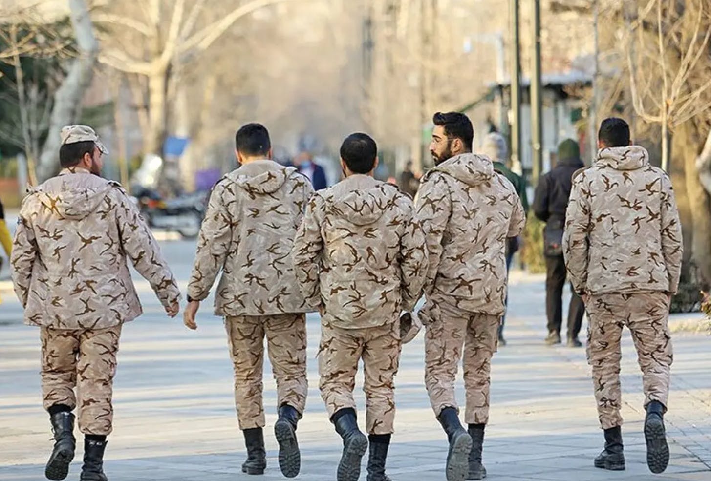 پنج سرباز در حال راه رفتن در ایی شبیه پارک