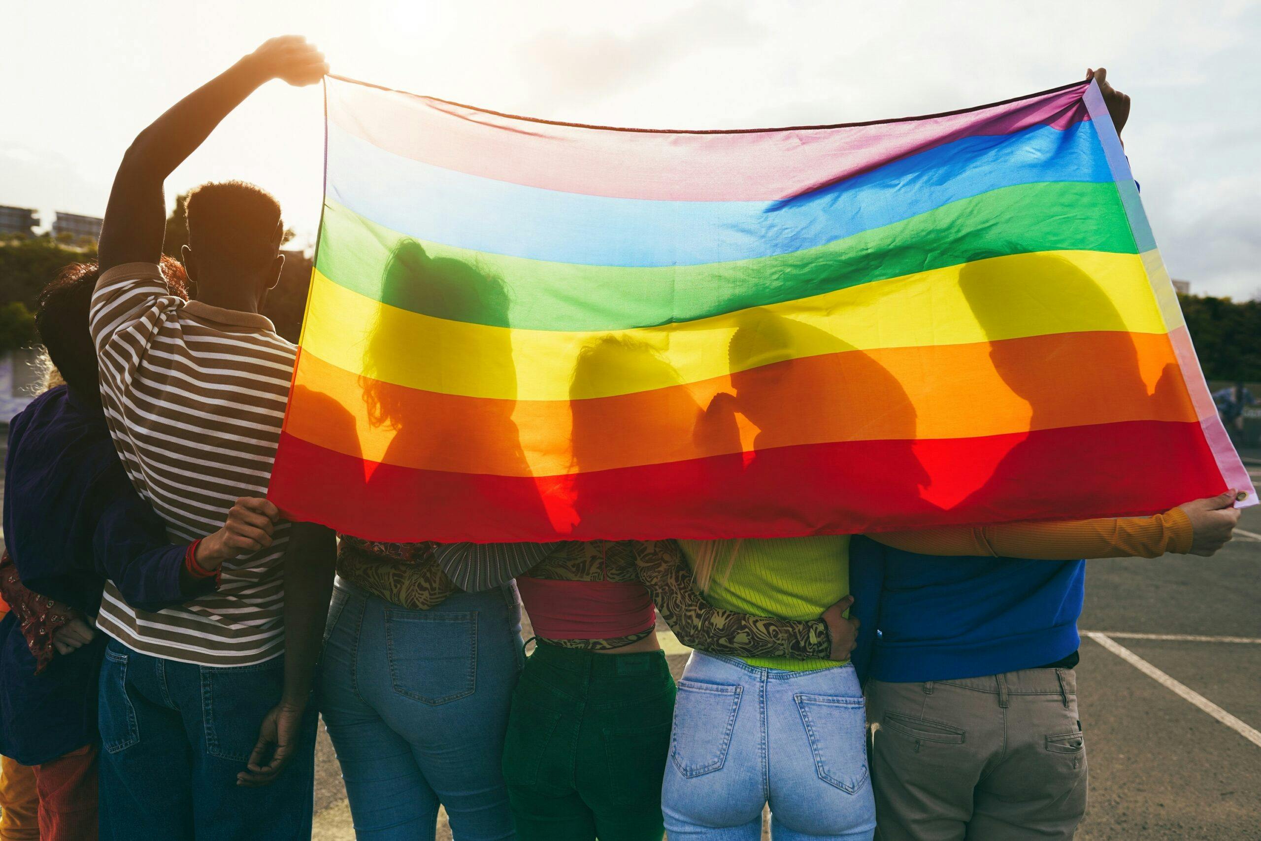 تصویر تزئینی از شاتر استاک پرچم رنگین‌کمان را پشت سر چند نفر نشان می‌دهد. افراد کوئیر در غنا نمی‌توانند تصویری از خود منتشر کنند چون با مجازات‌های حکومتی روبرو می‌شوند.