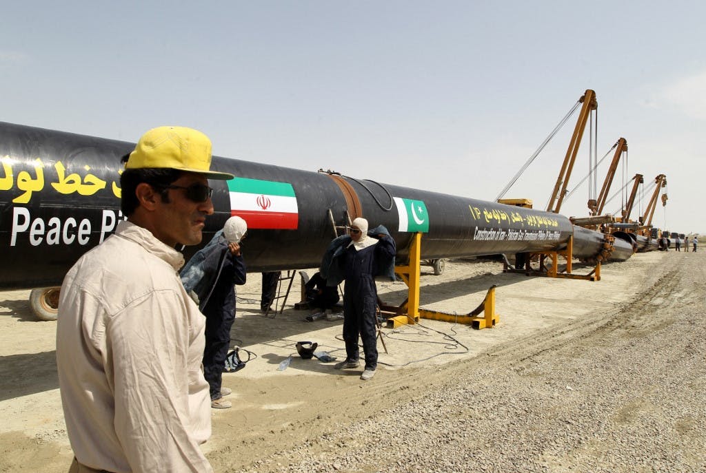خط لوله گاز ایران و پاکستان: کارگران در حال جوشکاری لوله‌های منقش به پرچم دو کشور هستند.
