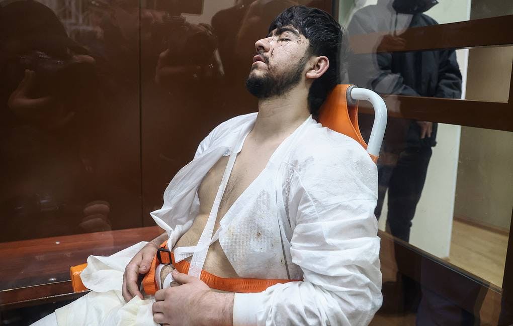 محمدصبیر فیضوف یکی از از چهار مظنون حمله به سالن کنسرت مسکو مستقیماً از بیمارستان با ویلچر به دادگاه آورده شد و در طول رسیدگی با چشمان بسته نشسته بود.