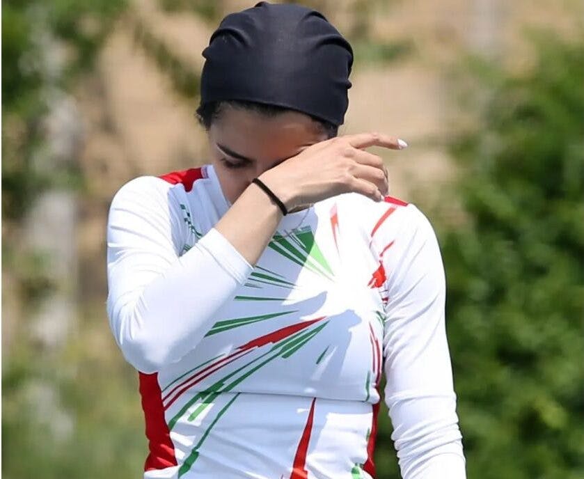فرزانه فصیحی با لباس تیم ملی ایران در حالی که دستش را جلوی صورتش گرفته است