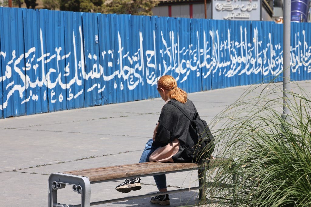 یک زن در ۱۳ آوریل ۲۰۲۴ روی نیمکتی در تهران پایتخت ایران استراحت می کند. پلیس در ایران در روز ۱۳ آوریل یک سرکوب جدید علیه زنانی که قوانین پوشش اسلامی سختگیرانه این کشور را نادیده می گیرند که پوشیدن روسری را برای آنها در اماکن عمومی اجباری می کند، اعلام کرد.