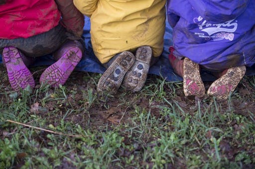 تصویری از سه جفت کفش بچه های مدرسه ای در طبیعت سبز