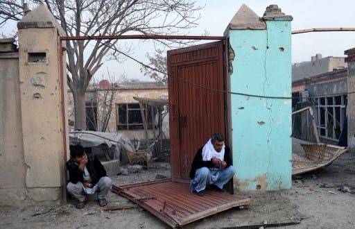 تصویری از دو مرد ناراحت در ویرانه خانه شان در افغانستان