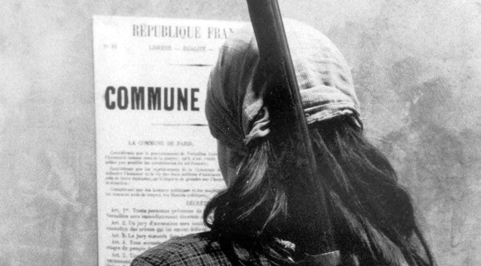 زنی با اسلحه که اعلامیه کمون پاریس را روی دیوار می‌خو‌اند