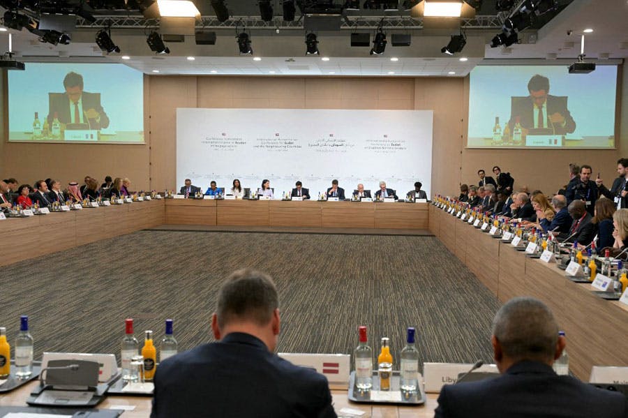 نمایندگان کنفرانس بین‌المللی سودان در پاریس پشت یک میز بزرگ دور تا دور سالن کنفرانس نشسته‌اند.