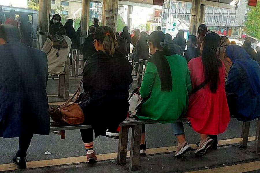 گروهی از زنان در ایستگاه اتوبوس حجاب از سر برداشته‌اند