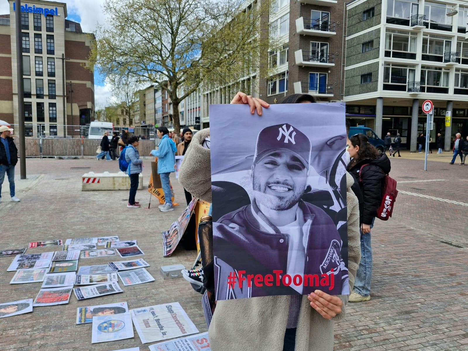 تصویر توماج صالحی در دست یک معترض در میدانی در هلند