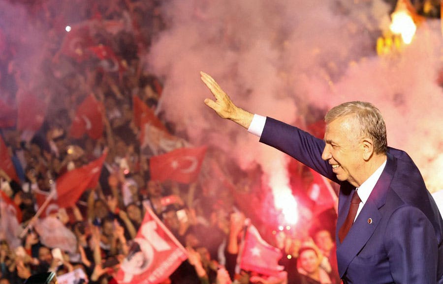 منصور یاواش، شهردار آنکارا و نامزد حزب جمهوری خلق (CHP) در انتخابات محلی ترکیه با خنده برای هواداران خود در آنکارا که پرچم‌های ترکیه را در دست دارند دست تکان می‌دهد.