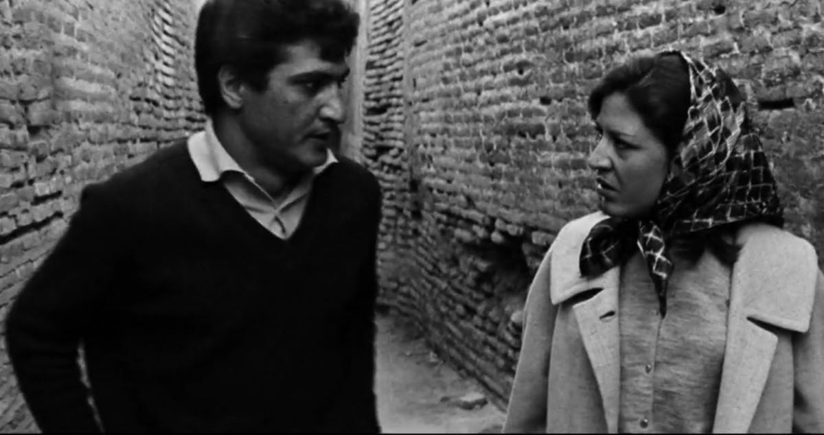 صحنه‌ای از نسخه بازسازی‌شده فیلم خشت و آیینه، ساخته ابراهیم گلستان که در یک کوچه شخصیت زن و مرد در حال بحث و جدل دیده می‌شوند.