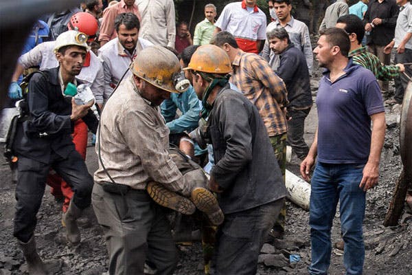 کارگران معدن یک کارگر را که دچار سانحه کاری شده از محل حادثه بیرون می‌کشند.