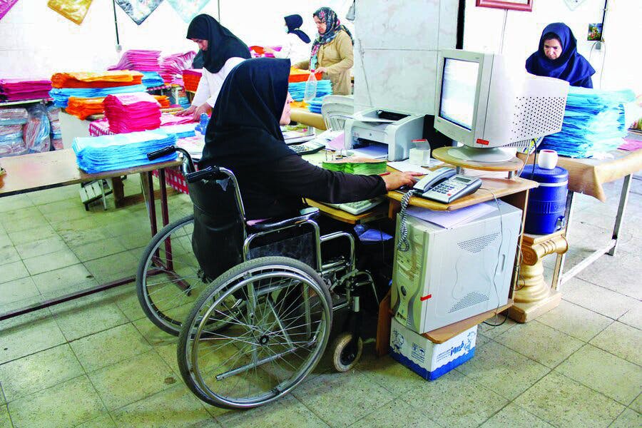 زنی معلول روی ویلچر در محل کار