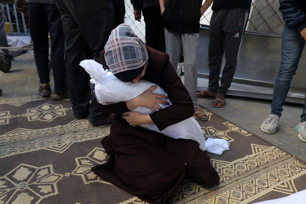 زنی در غزه که جسد کودک کشته شده اش را در حمله اسرائیل در آغوش گرفته