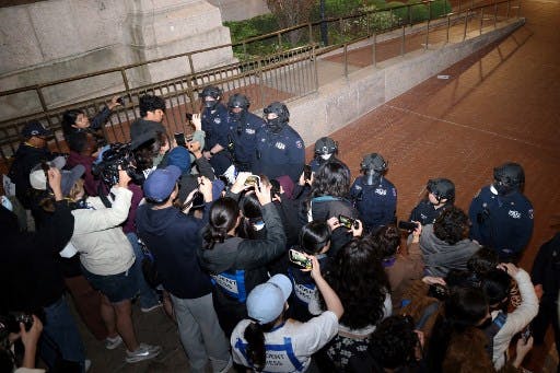 تصویر خبرگزاری فرانسه از حضور پلیس در دانشگاه کلمبیا در شهر نیویورک که به بازدادشت ۳۰۰ نفر منجر شد. در این تصویر گروهی از معترضان تلفن‌های هوشمندشان را جلوی صورت پلیس‌ها گرفته‌اند و عکس و فیلم می‌گیرند.
