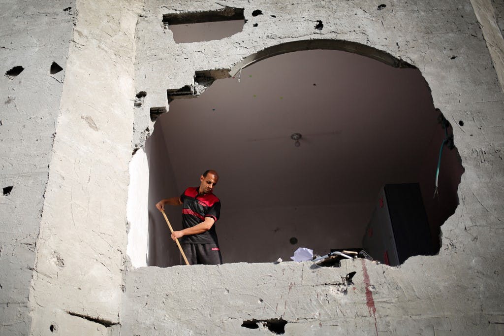 یک فلسطینی در حال برداشتن آوار ساختمانی که هدف حملات اسرائیل در غزه بوده است. AFP