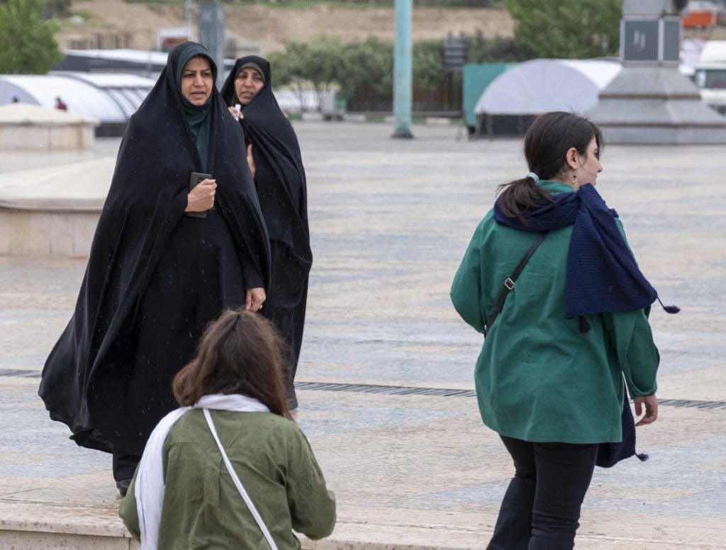 دو زن بدون حجاب از کنار دو زن چادرپوش می‌گذرند