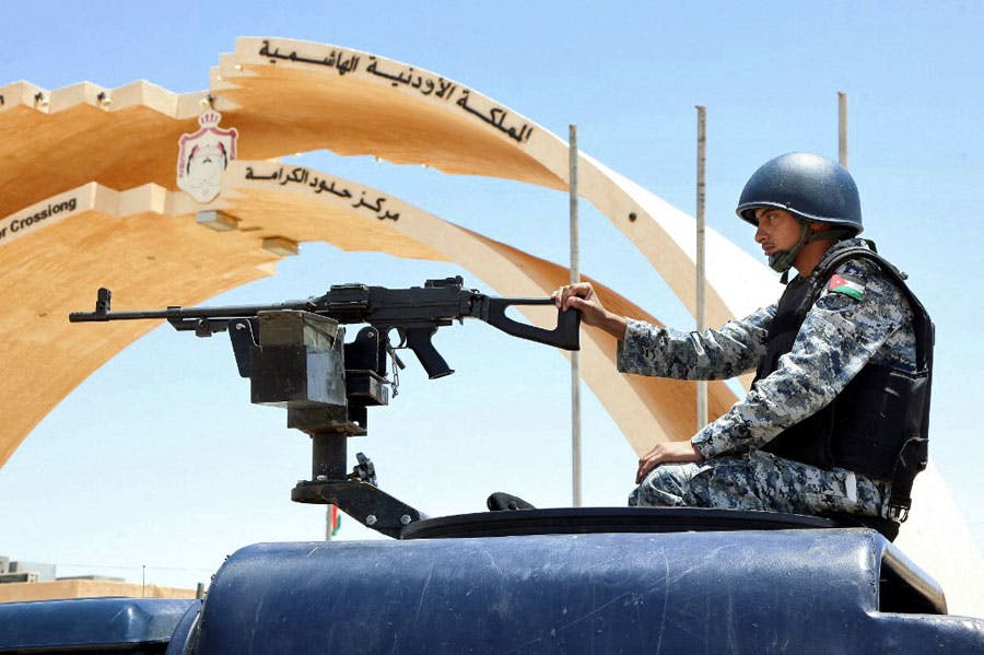 تصویری از یک مرزبان اردنی که پشت تیرباری در یک خودروی نظامی نشسته است.
