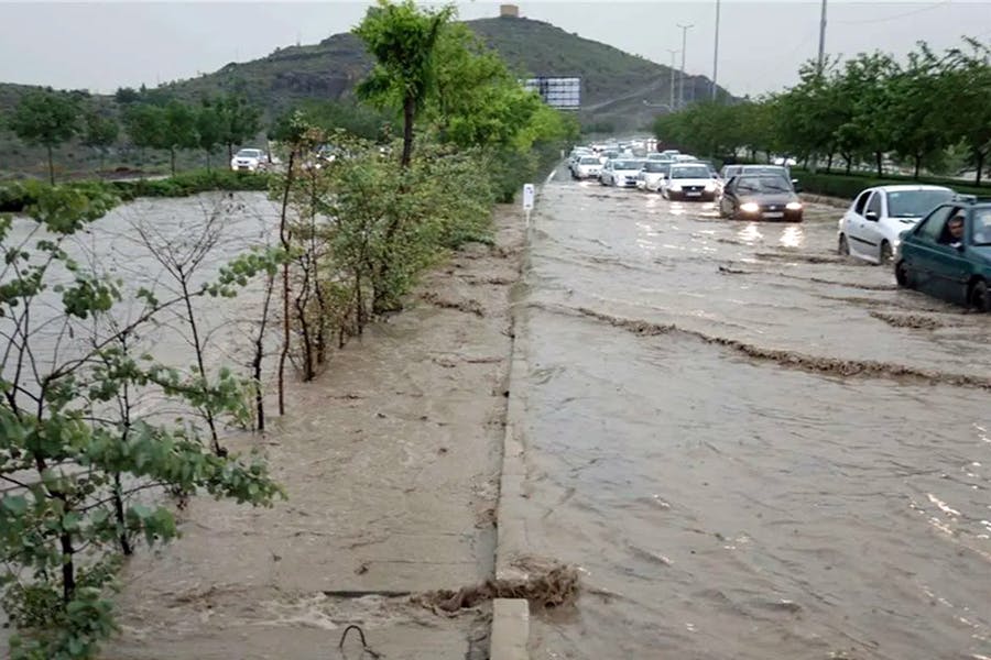 در تصویر بلواری در مشهد نشان داده می‌شود که سیلاب آن را فراگرفته و خودروها از میان آب می‌گذرند