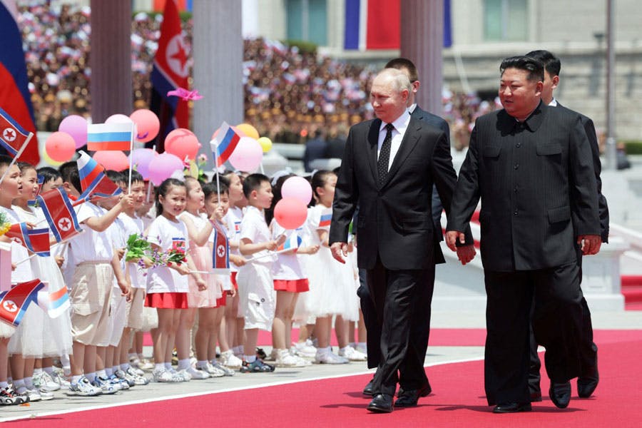 ولادیمیر پوتین، رئیس جمهوری روسیه و کیم جونگ اون، رهبر کره شمالی از مقابل صف کودکان کره‌ای که پرچم‌های دو کشور را تکان می‌دهند، با لبخند عبور می‌کنند.