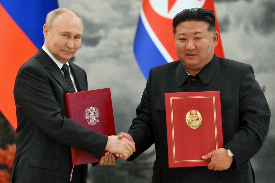 در این تصویر ولادیمیر پوتین، رئیس جمهوری روسیه پس از مذاکرات و مراسم امضای قرارداد با کیم جونگ اون، رهبر کره شمالی دست داده است. قراردادها در دست آن‌ها دیده می‌شوند.