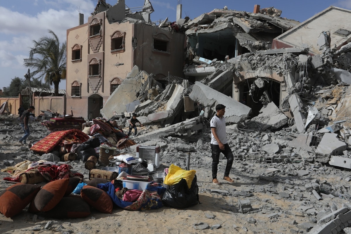 یک فلسطینی در رفح در غزه رد کنار خرابه های خانه ها ایستاده