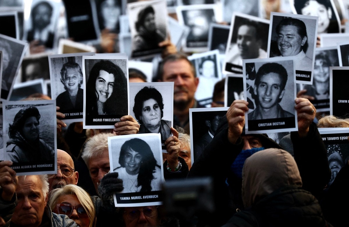 جمعی از مردم که عکسهای قربانیان انفجار انجمن همیاری یهودیان آرژانتین به دست جمهوری اسلامی و حزب‌الله لبنان را بالا گرفته‌اند