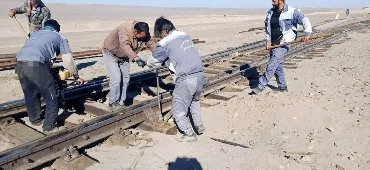 پنج کارگر راه آهن در گرمای روز در حال کارند